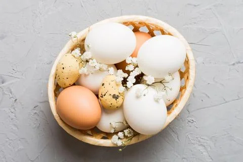 Happy Easter composition. Easter eggs in basket on colored table with gypso.. 库存照片