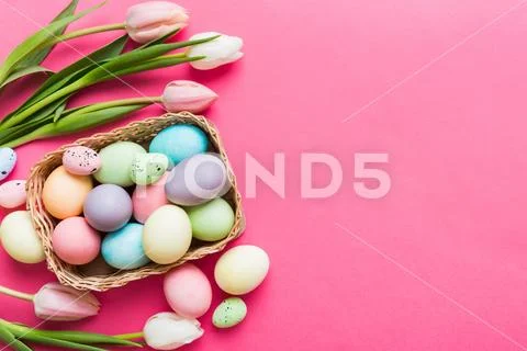 Happy Easter composition. Easter eggs in basket on colored table with yello.. 库存照片