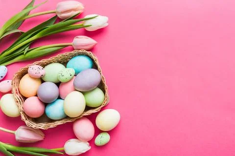 Happy Easter composition. Easter eggs in basket on colored table with yello.. 库存照片