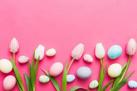 Happy Easter composition. Easter eggs on colored table with yellow Tulips. Na 库存照片