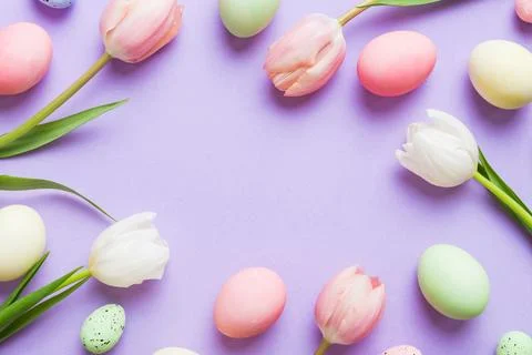 Happy Easter composition. Easter eggs on colored table with yellow Tulips. .. Foto stock