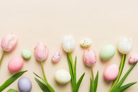 Happy Easter composition. Easter eggs on colored table with yellow Tulips. Na 스톡 사진