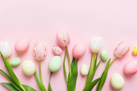 Happy Easter composition. Easter eggs on colored table with yellow Tulips. Na 写真素材