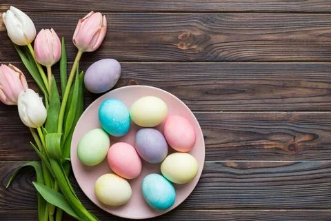 Happy Easter composition. Easter eggs in basket on colored table with yellow  스톡 사진
