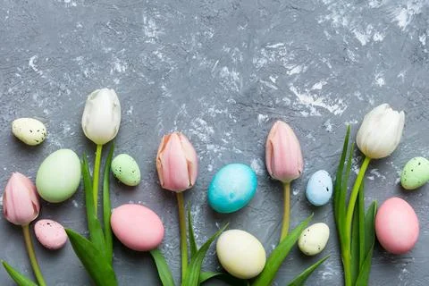 Happy Easter composition. Easter eggs on colored table with yellow Tulips. Na 스톡 사진
