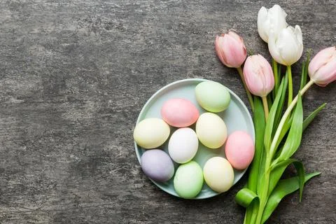 Happy Easter composition. Easter eggs in basket on colored table with yello.. 库存照片