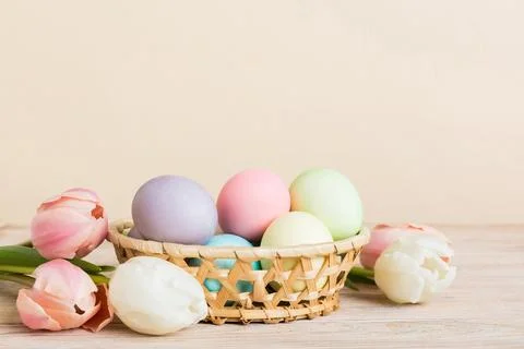 Happy Easter composition. Easter eggs in basket on colored table with yellow  스톡 사진