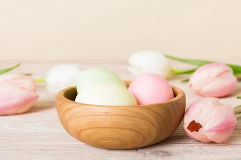 Happy Easter composition. Easter eggs in basket on colored table with yellow  스톡 사진