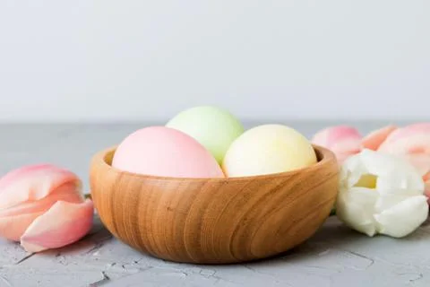Happy Easter composition. Easter eggs in basket on colored table with yellow  스톡 사진