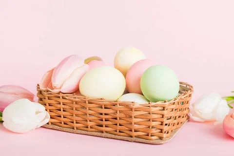 Happy Easter composition. Easter eggs in basket on colored table with yellow  스톡 사진