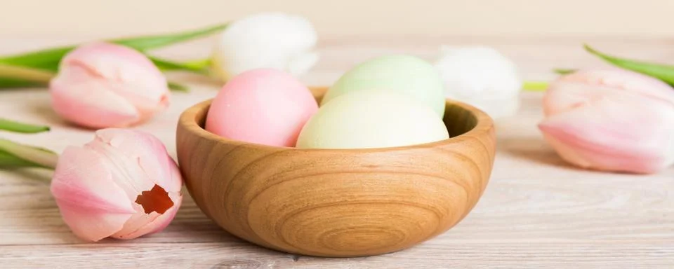 Happy Easter composition. Easter eggs in basket on colored table with yello.. Stock Photos