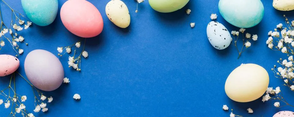 Happy Easter composition. Easter eggs on colored table with gypsophila. Natur Stock Photos