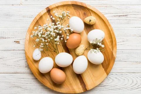 Happy Easter composition. Easter eggs in basket on colored table with gypso.. 库存照片