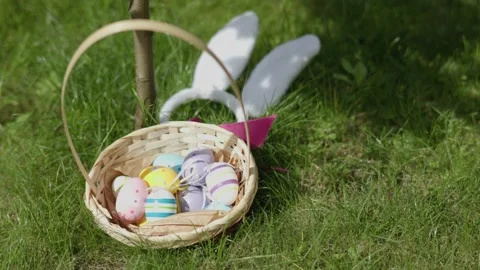 Happy easter concept basket full of bright easter eggs, bunny ears green grass Video stock 234560894
