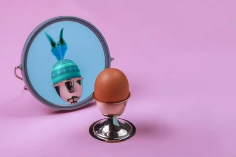 Happy Easter concept. Brown egg in silver cup reflected in a mirror as colored Illustrazione stock