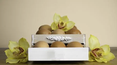Happy Easter concept. Chicken eggs in a rustic wooden box with spring flowers. Stock Photos