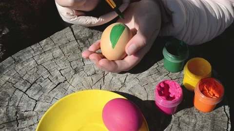 Happy easter concept. Close-up kid arms holding chicken's egg and color it to Stock Footage 172531098