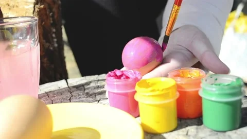 Happy easter concept. Close-up kid arms holding chicken's egg and color it to Stock Footage 173208180