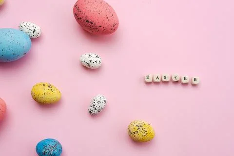 Happy Easter concept. Colorful eggs are laid out on a cute, pink background. Stock Photos