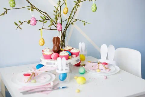 Happy Easter concept - decorated table with cupcakes, colorful painted eggs a Stock Photos