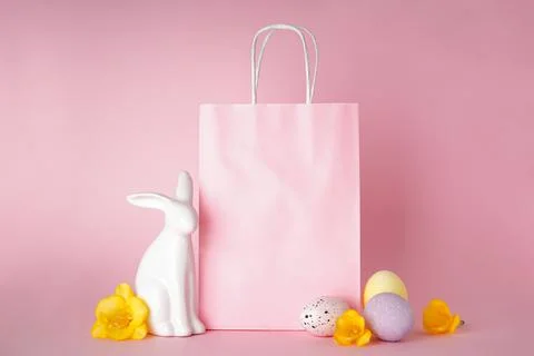 Happy Easter concept. Easter bunny and colored Easter eggs with paper bag on Stock Photos