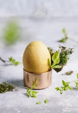 Happy easter concept. Easter painted egg in yellow tones in an egg cup and br Stock Photos