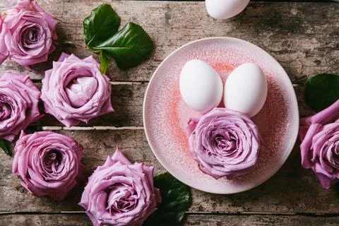 Happy easter concept. Eggs and roses on a wooden background. Stock Photos