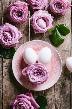 Happy easter concept. Eggs and roses on a wooden background. Stock Photos