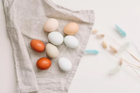 Happy Easter concept. Fresh chicken eggs of natural shades and colors on a white Stock Photos