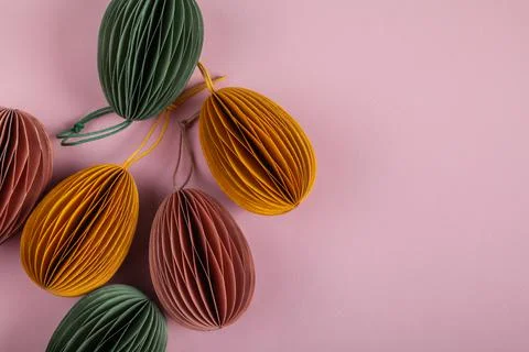 Happy easter concept. Multicolored easter eggs made of paper on a pastel pink Stock Photos