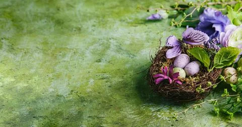 Happy easter concept. Multicolored easter painted eggs in the nest, flowers a Stock Photos
