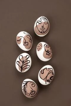 Happy Easter concept. Surreal faces on eggs on brown background. Art und Onli Foto stock