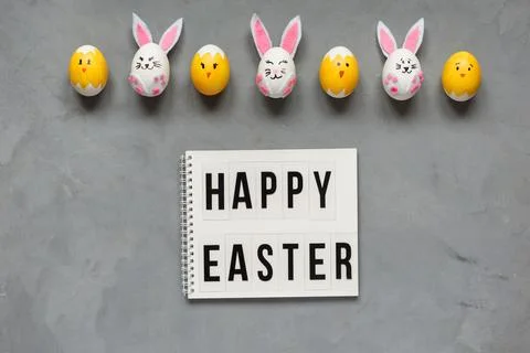 Happy Easter congratulation on the grey background. Easter eggs and bunnies. Stock Photos