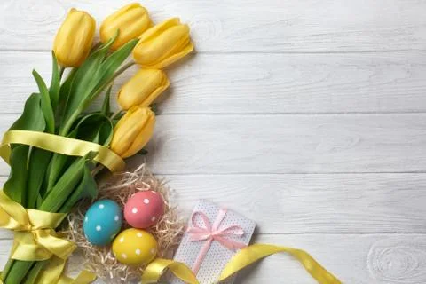 Happy Easter. Congratulatory easter background. Easter eggs and flowers. Stock Photos
