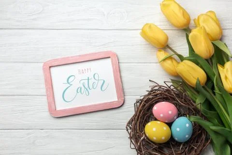 Happy Easter. Congratulatory easter background. Easter eggs and flowers. Stock Photos