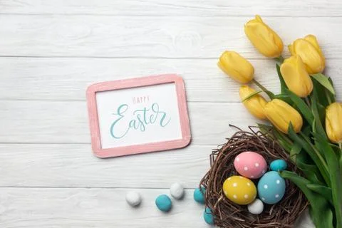 Happy Easter. Congratulatory easter background. Easter eggs and flowers. Stock Photos