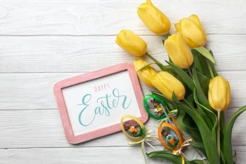 Happy Easter. Congratulatory easter background. Easter eggs and flowers. Stock Photos
