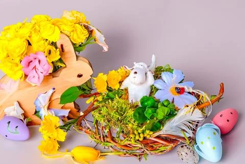 Happy Easter. Congratulatory easter background. Easter eggs, lamb and flowers. Stock Photos