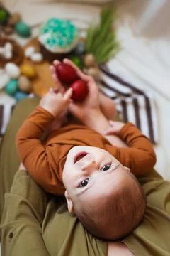 Happy Easter. Cute and happy little baby playing with Easter eggs and cake at Stock Photos