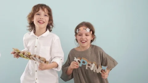 Happy Easter. Cute blue-eyed children hold wooden inscriptions Welcome and Stock Footage 102226760