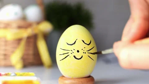 Happy Easter. Cute face with mustache on the eggshell of a painted yellow egg. Stock Footage 234686710
