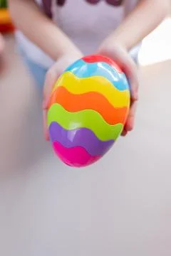 Happy Easter day. Kid hand with colorful egg toy. Stock Photos