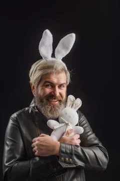 Happy Easter day. Smiling man in bunny ears with plush bunny toy. Stock Photos