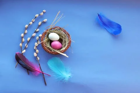 Happy Easter, decor, basket with painted eggs, bright feathers Stock Photos