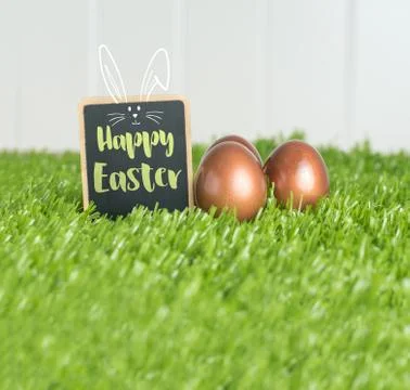 Happy easter with doodle rabbit on blackboard and rose gold color easter eggs Stock Photos