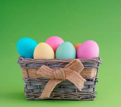 Happy easter, dyed colored eggs in the basket on the one-color background. Foto stock
