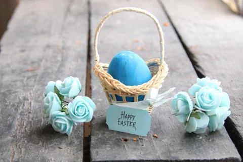 Happy easter. Easter egg in a basket on a vintage background and spring flowers Stock Photos