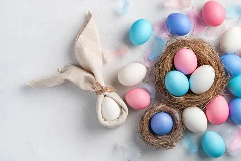 Happy Easter. Easter eggs and a rabbit from a napkin on a gray background. Stock Photos