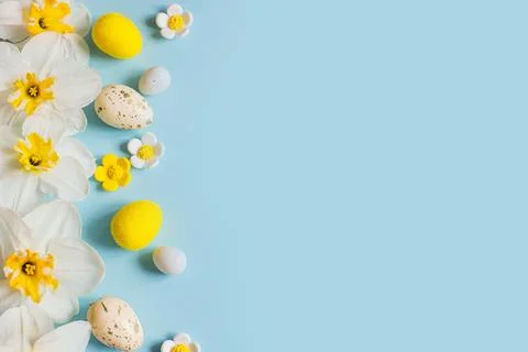 Happy Easter! Easter eggs and yellow daffodils flowers flat lay on blue bac.. Stock Photos
