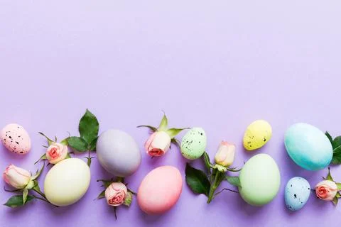 Happy Easter. Easter eggs on colored table with yellow roses. Natural dyed co 스톡 사진